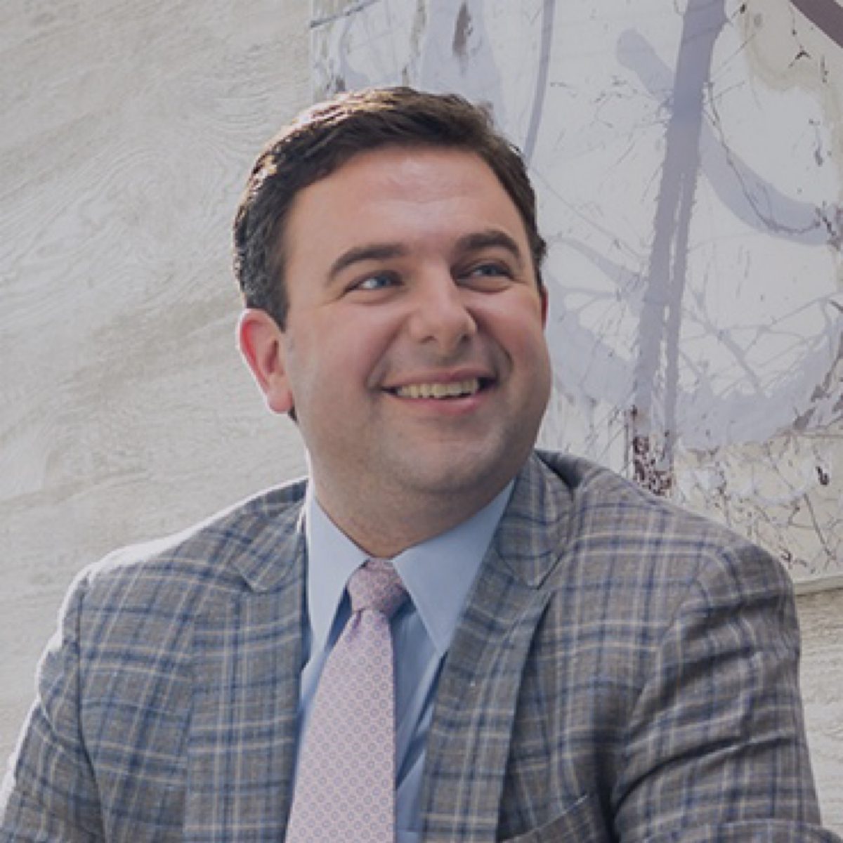 Chris Itteilag, Washington DC luxury real estate agent and Founder of SERHANT. Washington DC Capital Region, smiling in a plaid jacket and pink tie